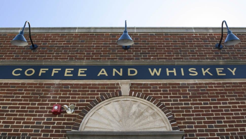 The facade of Char and Stave, a brick wall that reads coffee and whiskey.