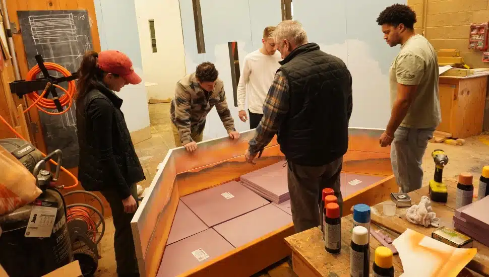 Horticulture students work with professor on flower show exhibit.