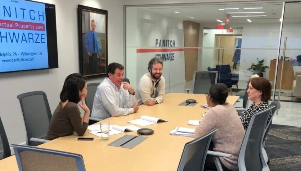 Lawyers talk around table in conference room.