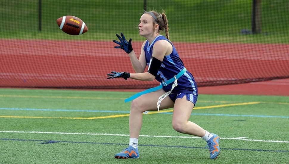 An Immaculata University Women's Flag Football Player catching the ball.