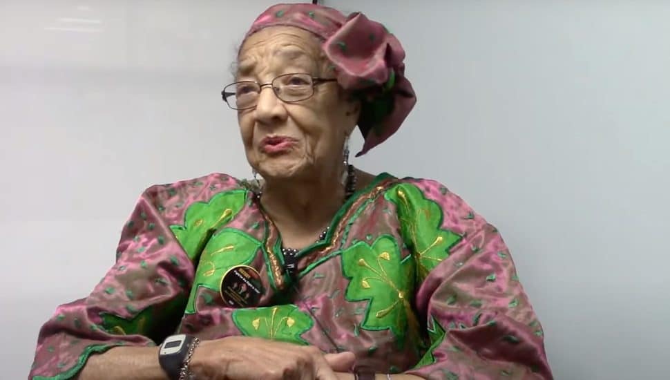 Caroline M. Merrill sitting in a purple and green dress.