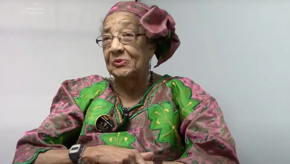 Caroline M. Merrill sitting in a purple and green dress.