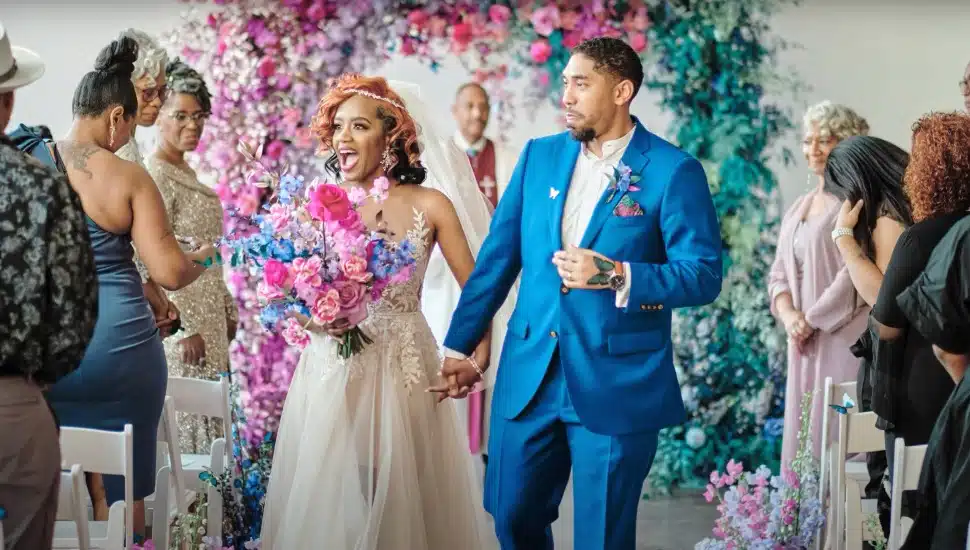 Nisha Dent and Kevin Crawley walking down the colorful aisle of their wedding.