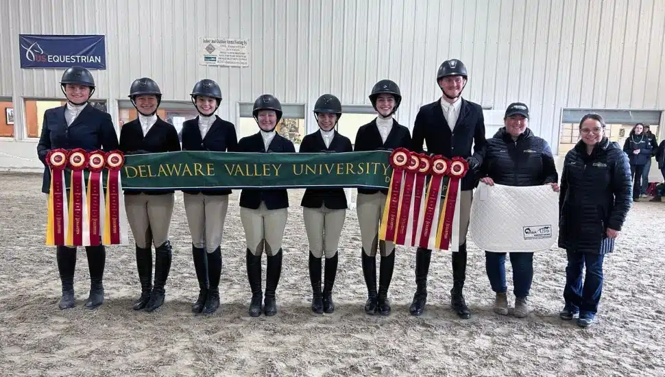Equestrian competitors pose for picture with awards.
