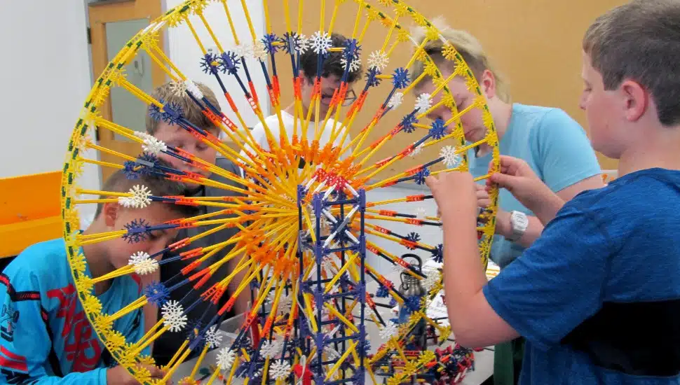 Kids build a lego ferris wheel at summer camp.
