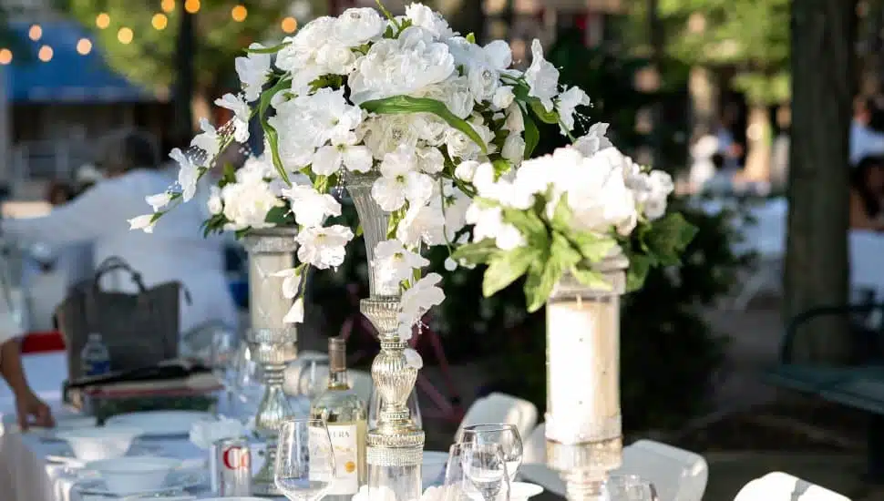 A white floral centerpiece on a table.