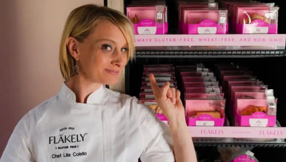 Pastry chef Lila Colello pointing to her Flakely Gluten Free Pastry ATM.