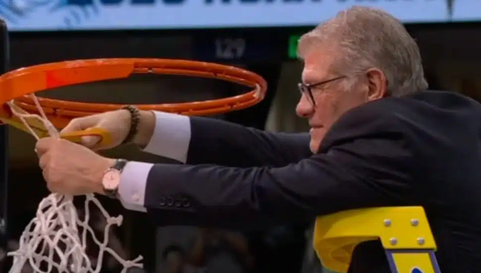 Geno Auriemma cutting down the net after the NCAA championship voctory.