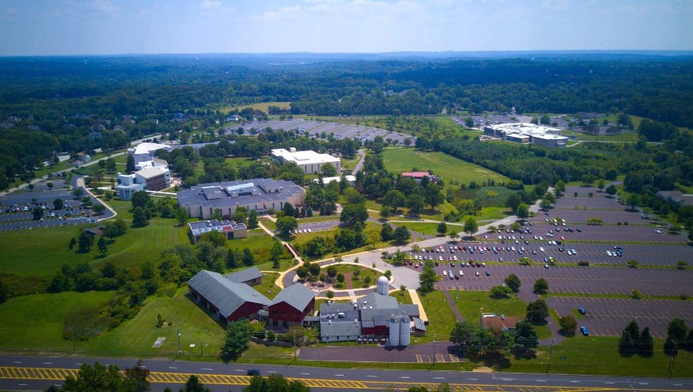 MCCC Blue Bell Campus. An aerial view showing lush green grass and trees with buildings, walkways.