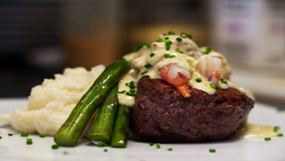 A filet mignon with mashed potatoes and string beans.