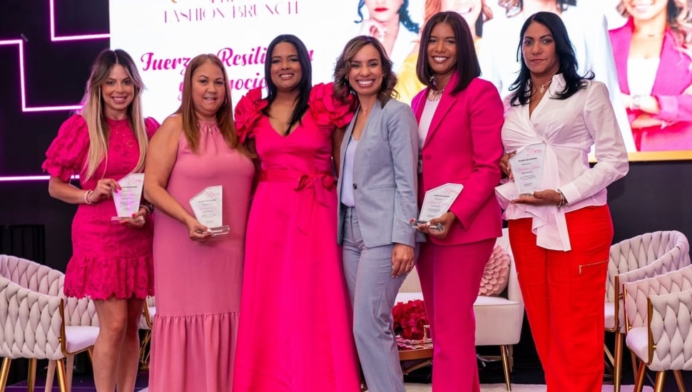 Latina entrepreneurs stand on stage together.