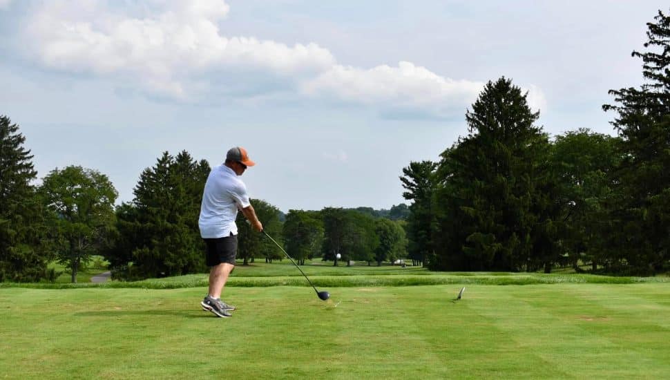 Man on the green hitting a golf ball at Penn Oaks Golf Club.