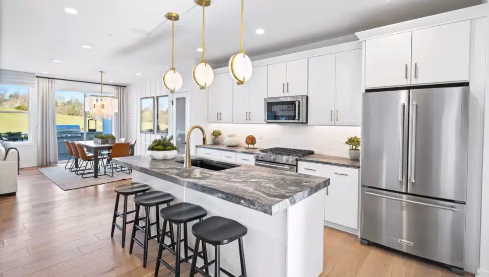 A modern kitchen with a sit-down island and stainless steel appliances.