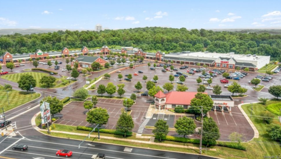 Suburbia Shopping Center aerial view with lots of parking and trees.