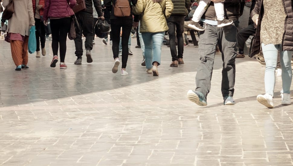 A crowd of pedestrians crossing street in the city, People walking in the street. Big city life. Crowd walking - group of people walking together.
