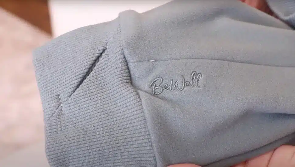 A sweater sleeve with BeWell stiched.