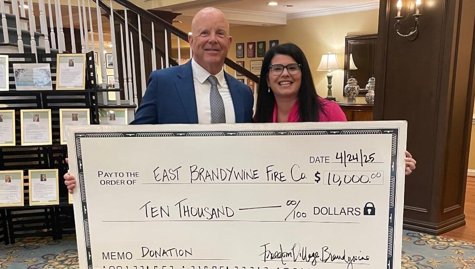 John Edwards, president of the East Brandywine Fire Company, and Danielle Geyer, executive director at Freedom Village at Brandywine hold a representative donation check for $10,000.