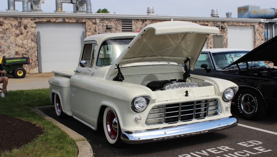 Classic car with open hood at car show.