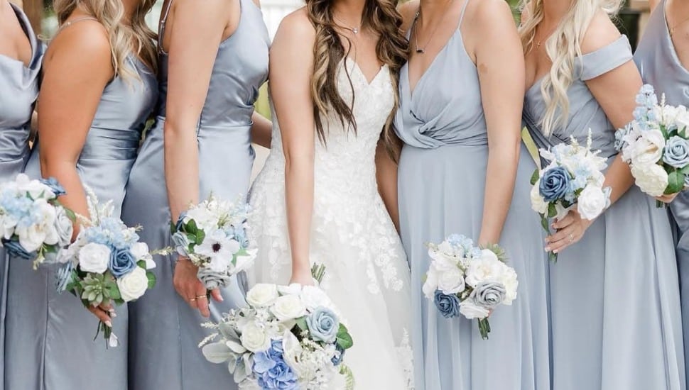 A focus on the dresses of a bride and her bridesmaidss.