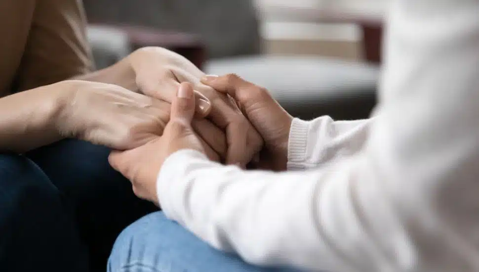 Two people comfort each other in grief.
