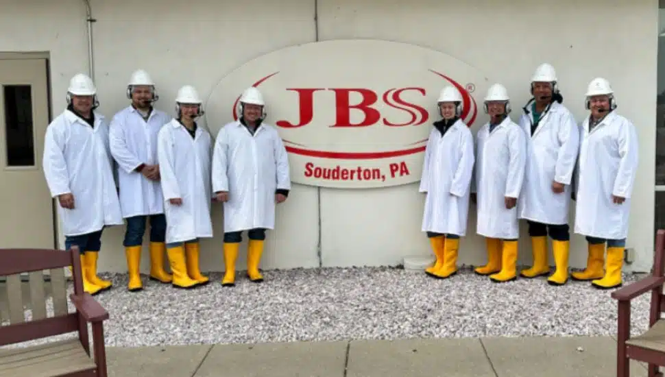 JBS workers pose around JBS Souderton sign.
