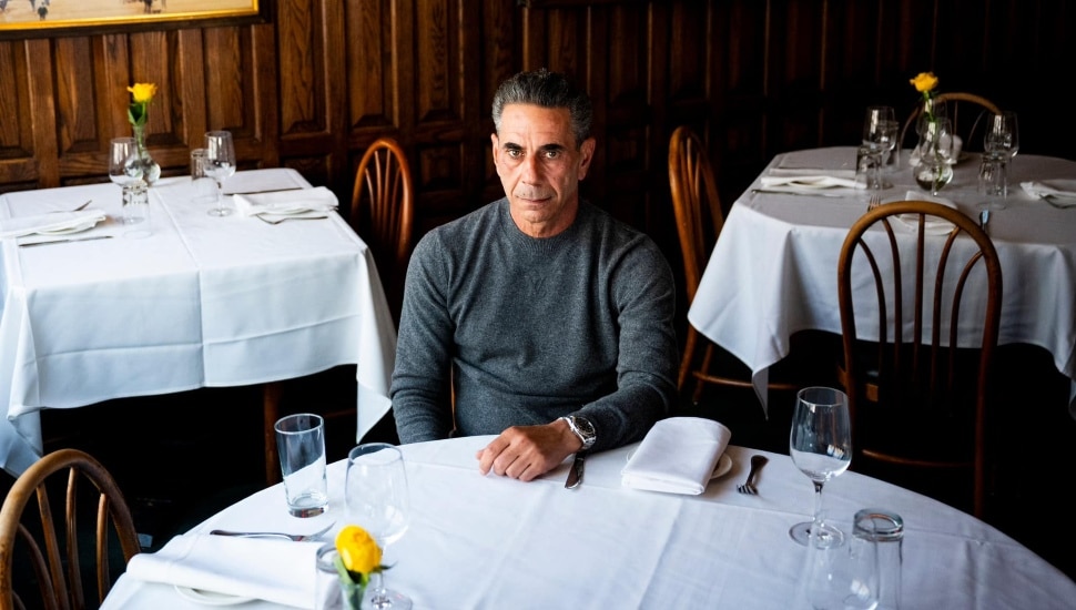 Joey Merlino sitting at a table in an empty restaurant.
