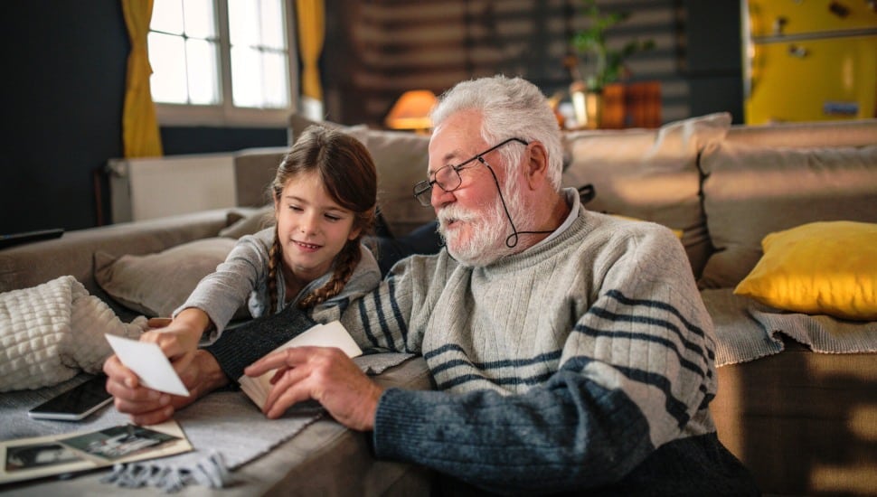 Grandad showing her granddaughter memories from past.