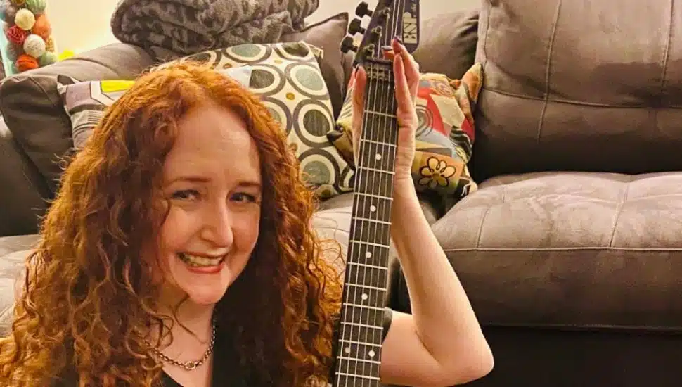 Pam Biasi holding her signed Live AID guitar from the Thompson Twins