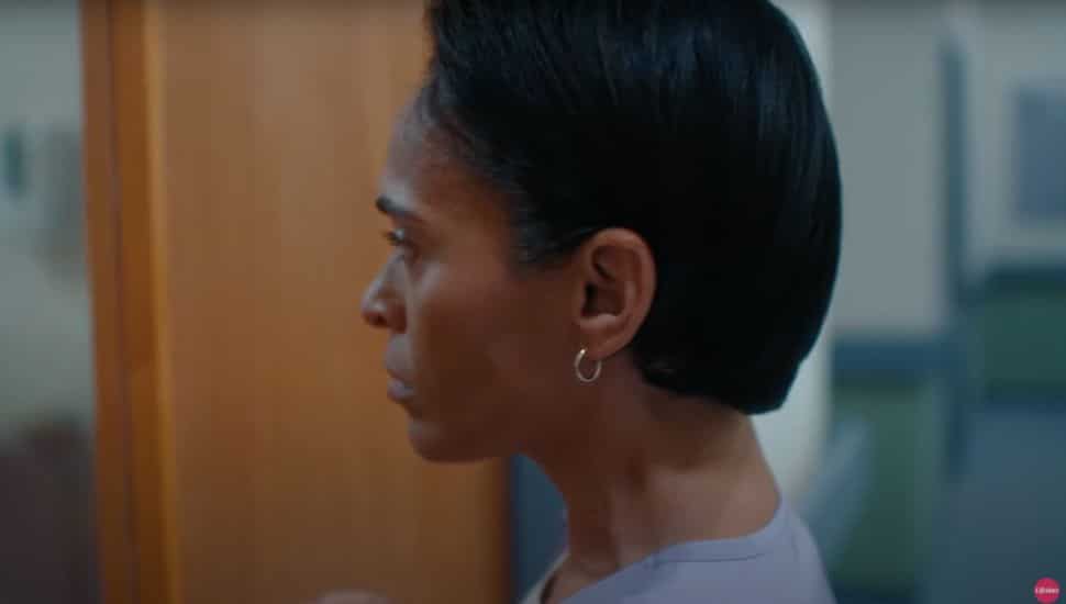 Actress looks through hospital door in 'Pretty Hurts' film.