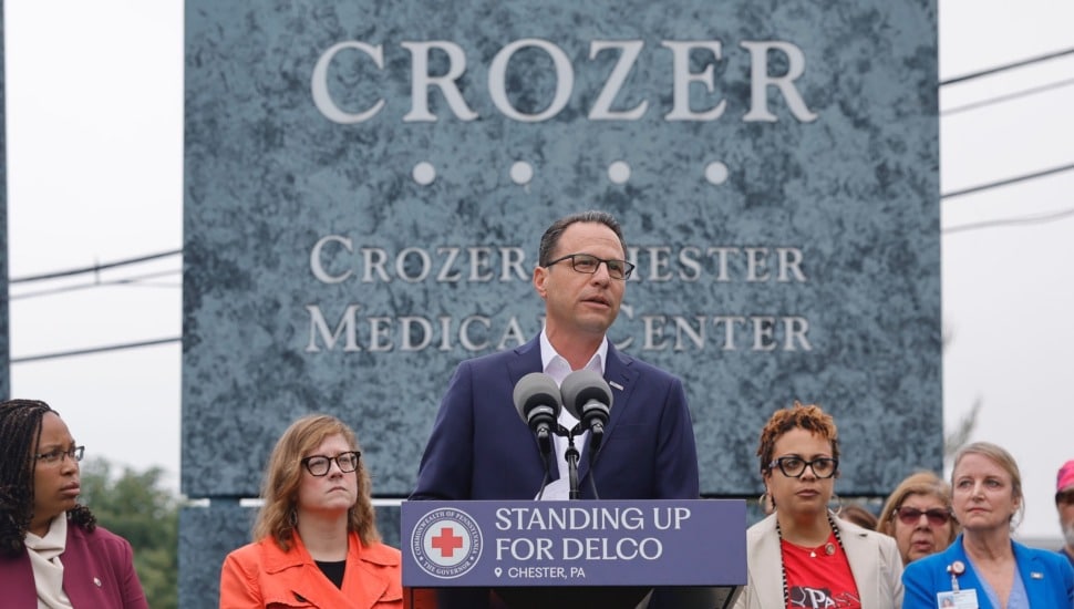 Pennsylvania Gov. Josh Shapiro addresses the crowd in front of the Crozer-Chester Medical Center sign at the new-closed facility.