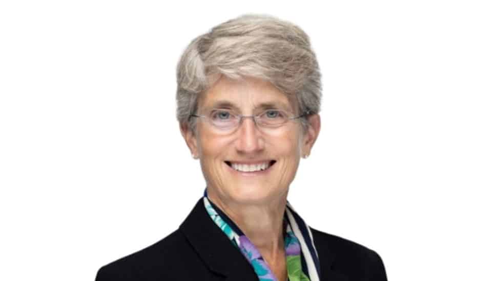 Headshot of older female banking executive with short gray hair and glasses.