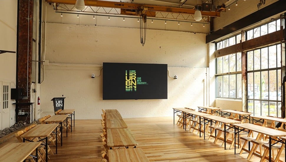 Lecture hall in an industrial setting with mounted television.