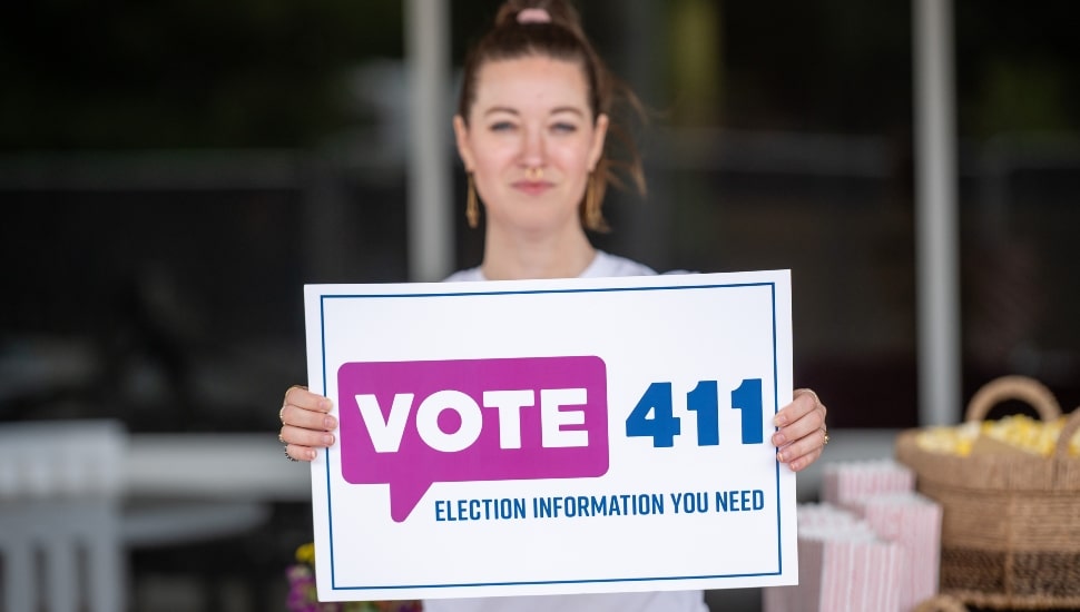 Woman holding Vote 411 sign.