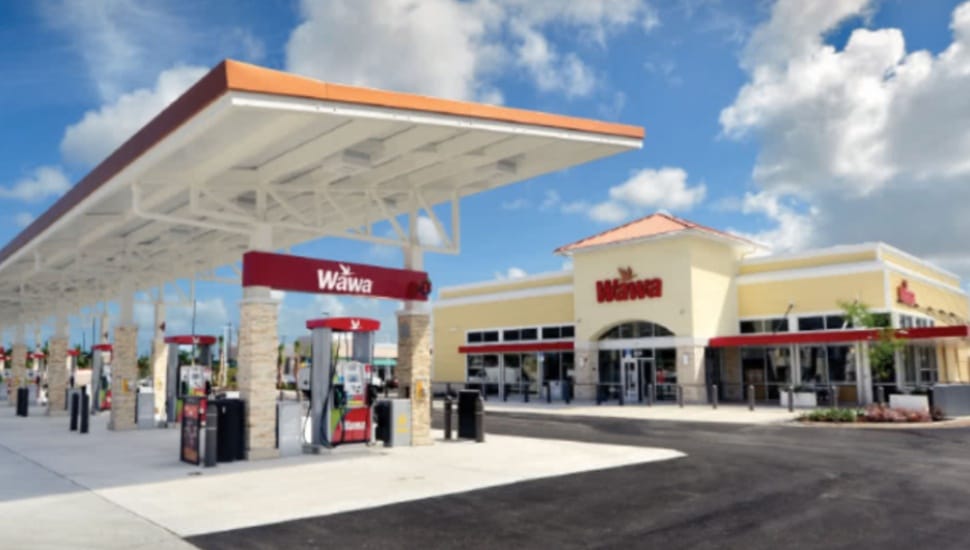 A Wawa store with gas pumps under blue skies.