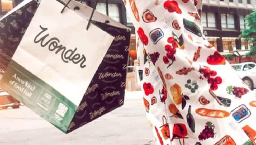 A woman in colorful pants carries out her Wonder ToGo bag.