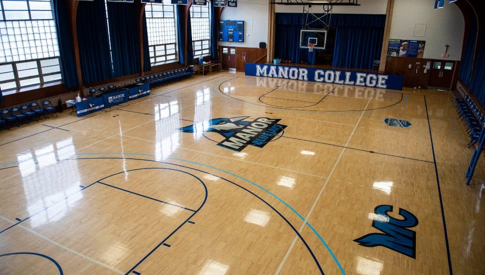 Empty gymnasium at Manor College featuring the Blue Jays logo and basketball court, soon to be home to new Women’s Flag Football and Men’s Volleyball teams starting in 2025.