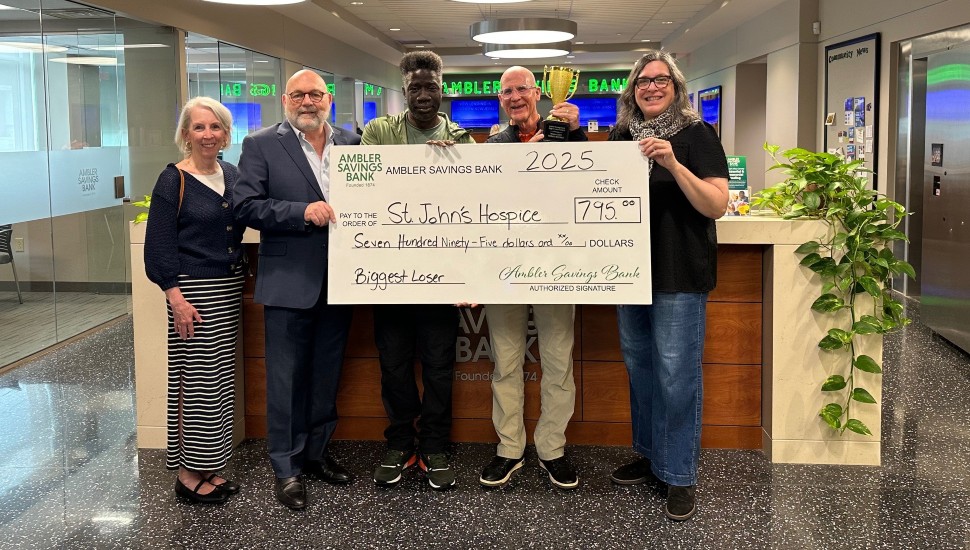 Bank employees donate giant check to nonprofit.