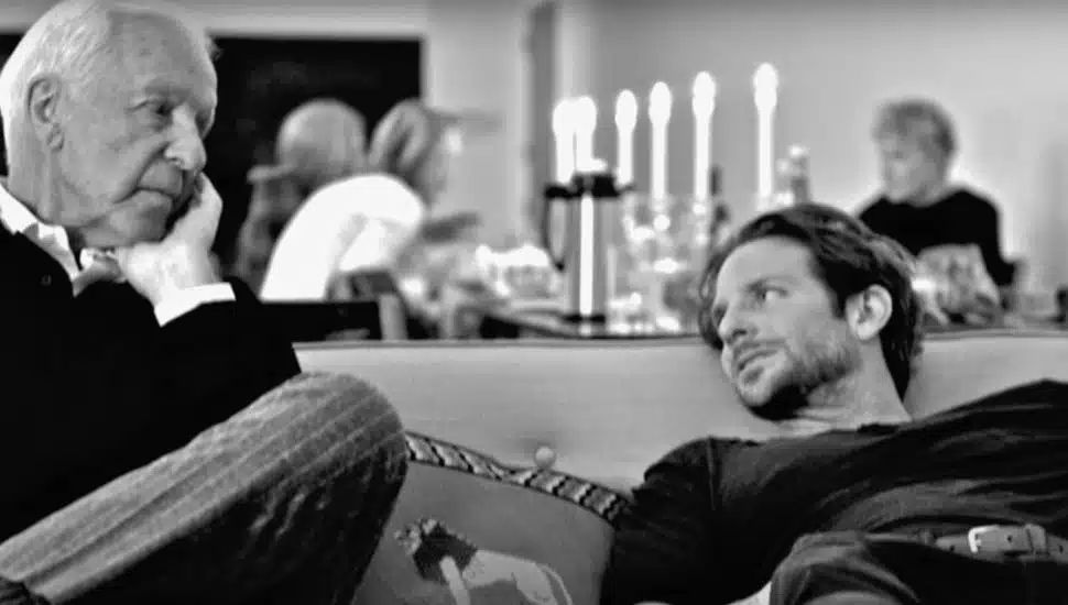 Bradley Cooper sits on a couch with his father, Charles.