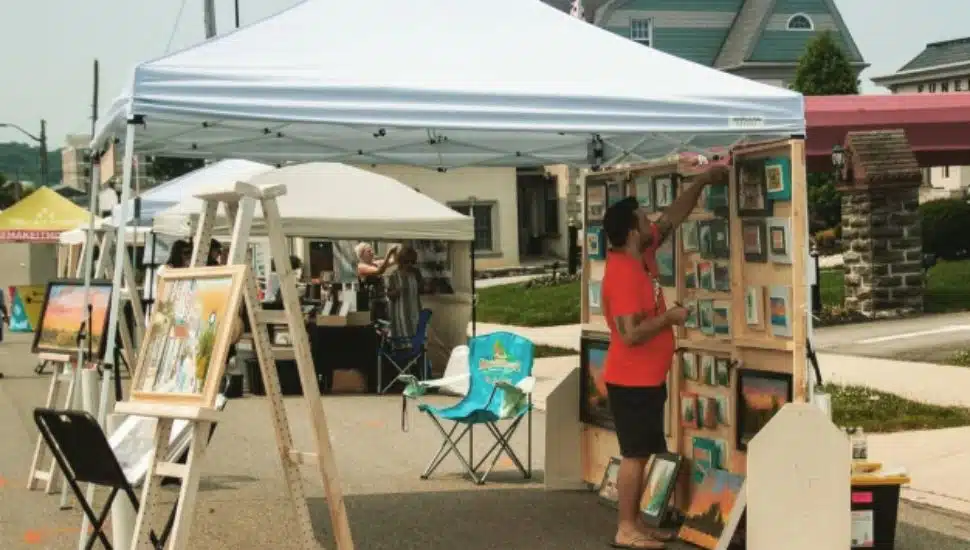A local artists sets up a tent for the Conshohocken Art Festival.