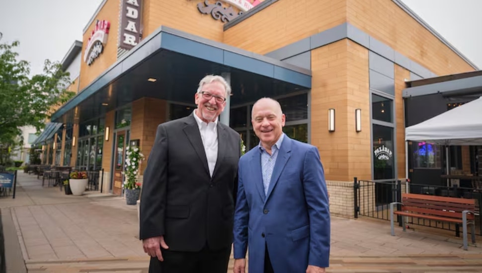 Larry Cohen and Barry Gutin with restaurant behind them.