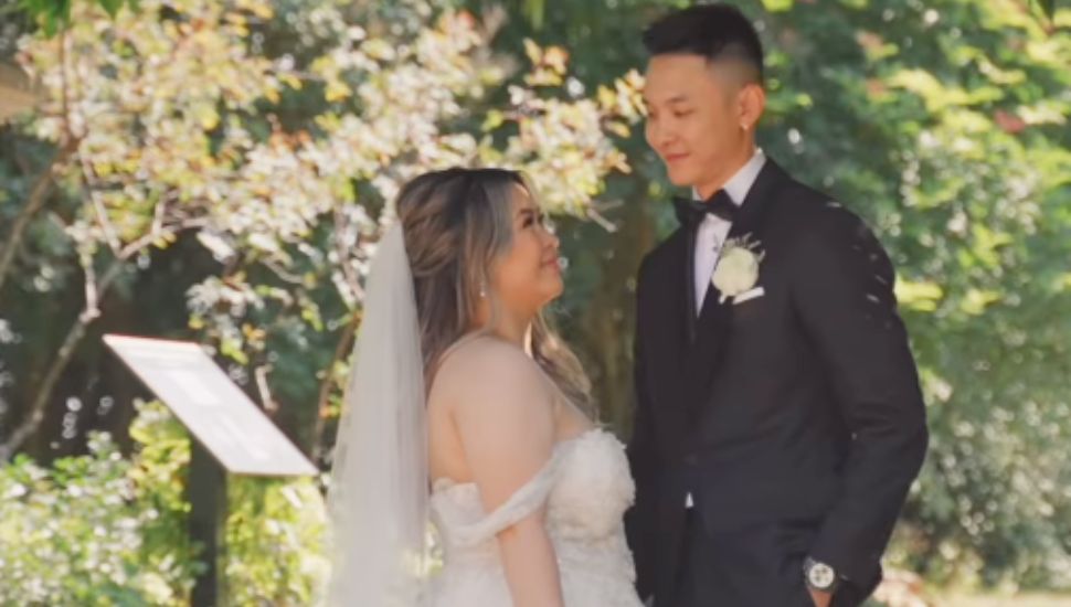 A Bride and Groom smiling and embracing one another.