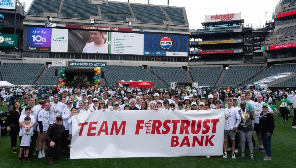 Group photo of bank employees at football stadium.