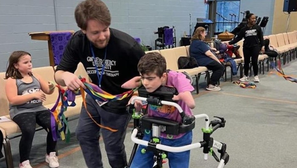 Male occupational therapist works with student.