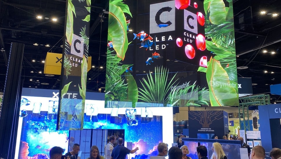 Audiovisual trade show with bright lights and screens.