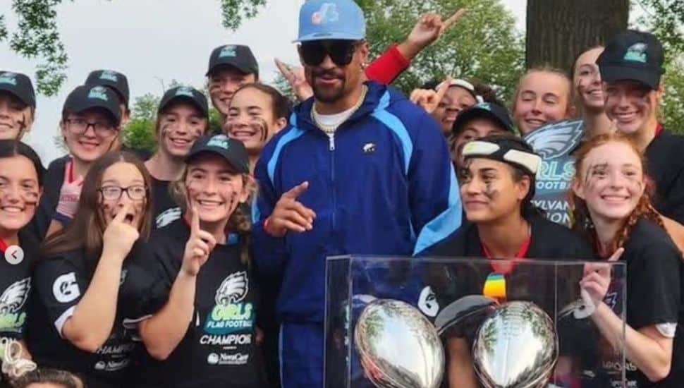 Jalen Hurts poses with the Gwynedd Mercy Academy girls' flag football team.