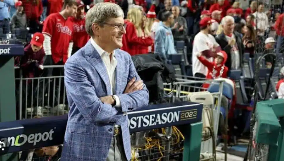 John Middleton stands with arms folded outside of the Phillies dugout.