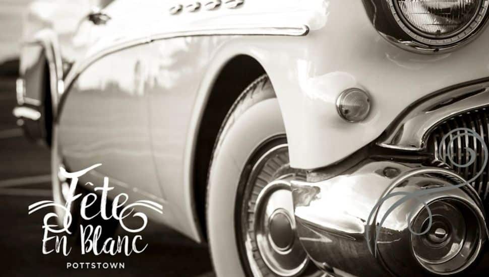 A white classic car with the Fete en Blanc logo.