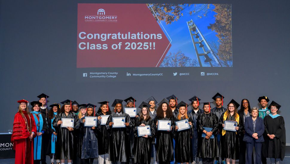 Seventeen students proudly received their high school diplomas on May 21 after completing the Gateway to College Program at Montgomery County Community College. They are gathered on stage holding diplomas and dressed in caps and gowns.