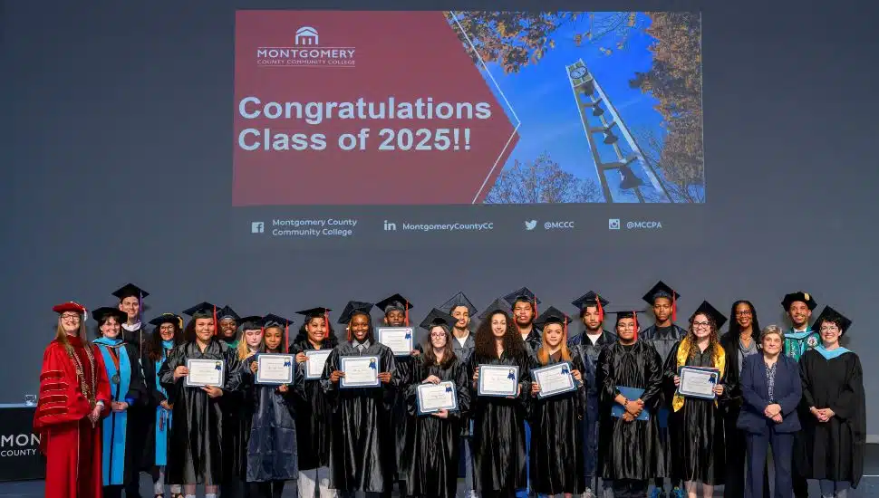 Seventeen students proudly received their high school diplomas on May 21 after completing the Gateway to College Program at Montgomery County Community College. They are gathered on stage holding diplomas and dressed in caps and gowns.