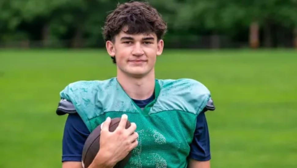 Xavier Stearn in his gear, clutching a football.